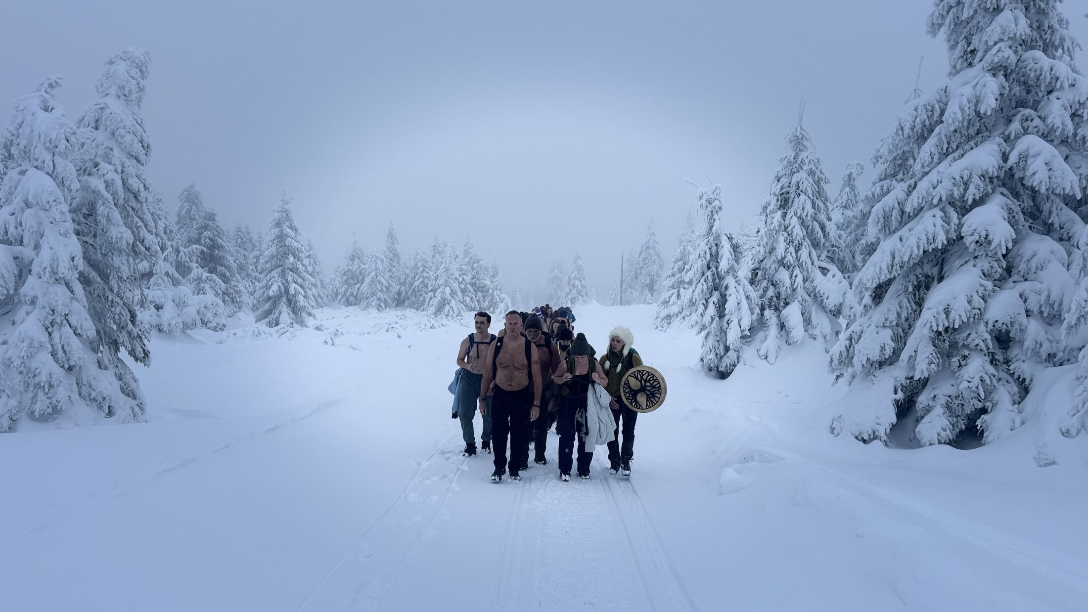 Expedition group walking through a snow-covered forest
